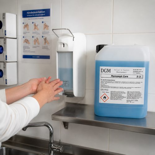 DGM Manosept Care Händedesinfektionsmittel 5 Liter beim Nachfüllen eines Desinfektionsspenders in einer professionellen Küche.